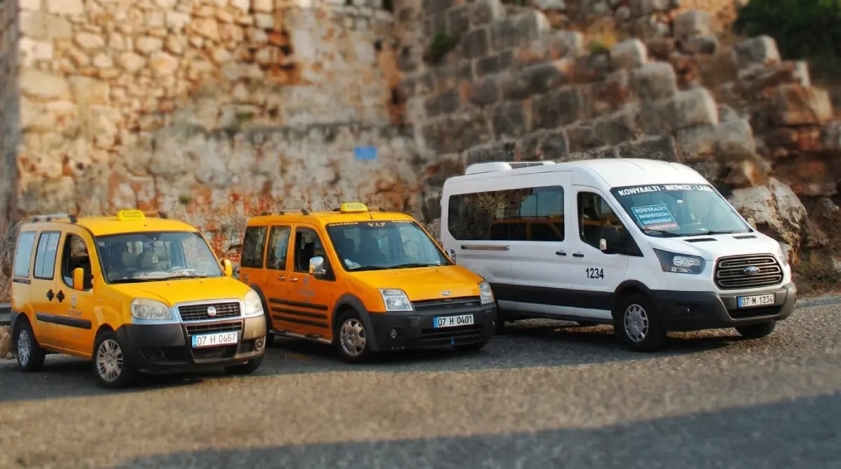 Lokalny transport w Turcji: tradycyjny biały minibus dolmusz obok charakterystycznych żółtych taksówek